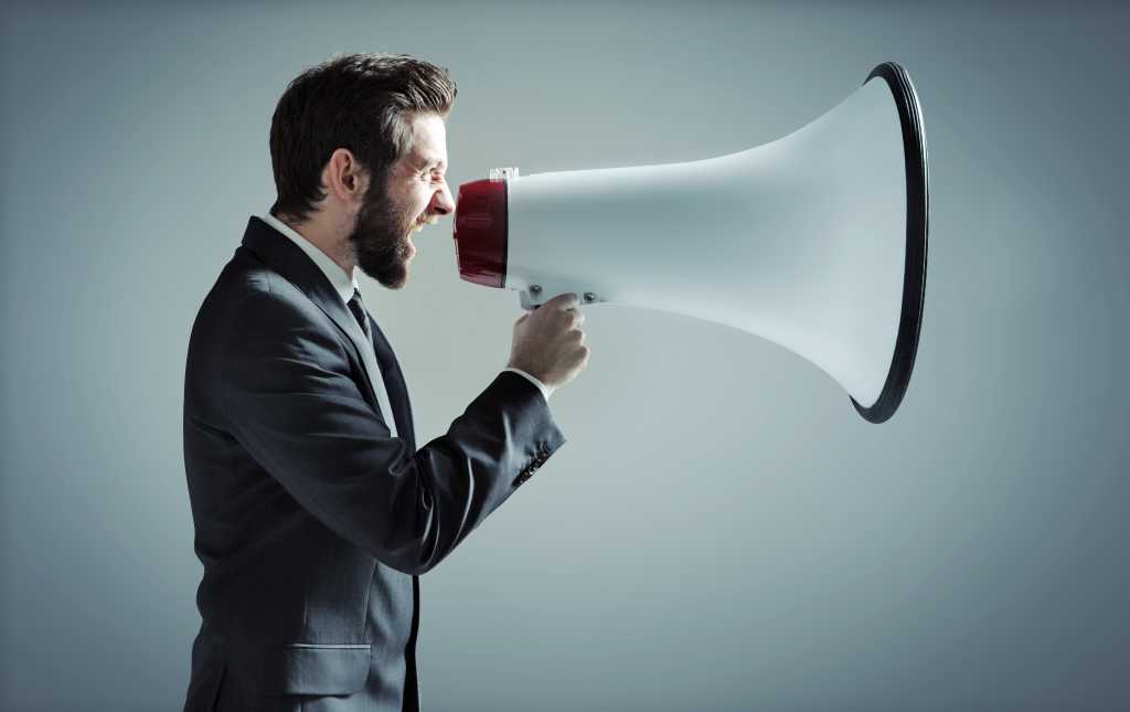 Young businessman with megaphone.